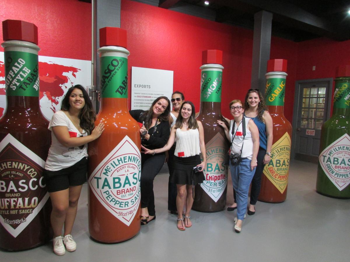 tourists pose in front of tabasco bottles at new museum