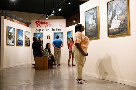 Woman looking at paintings at Bayou Teche Museum