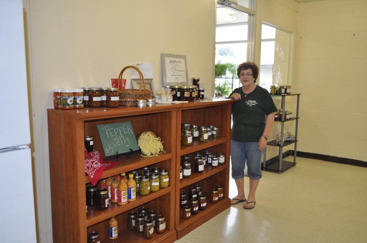 GLC worker standing in front of jarred preserves in GLC store