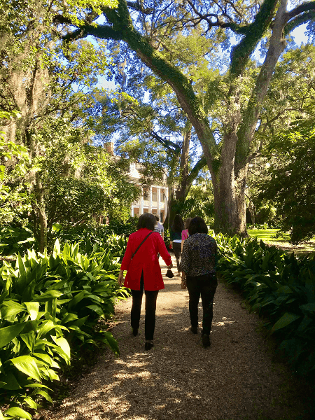 A group of women walks in the gardens of the Shadows on the Teche plantation home in New Iberia