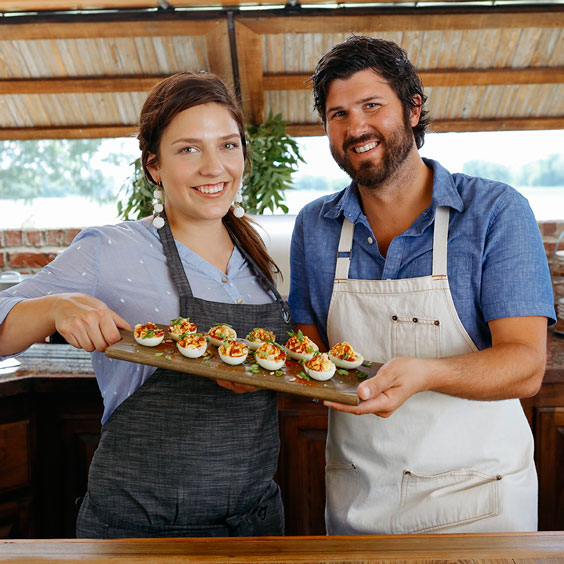 Chefs Cody and Samantha Carroll holding an egg dish