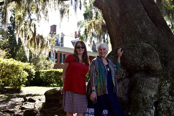 Visitors pose with oak tree at Shadows-on-the-Teche