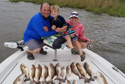Family fishing on a boat - Photo by Smokin' Reels Charters