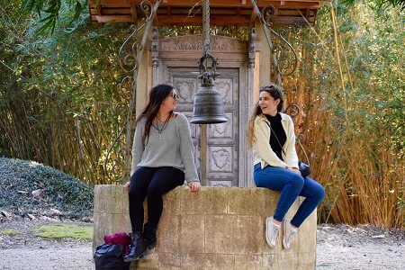 Two girls sit on the edge of a well at Jefferson Island Rip Van Winkle Gardens in New Iberia, Louisiana
