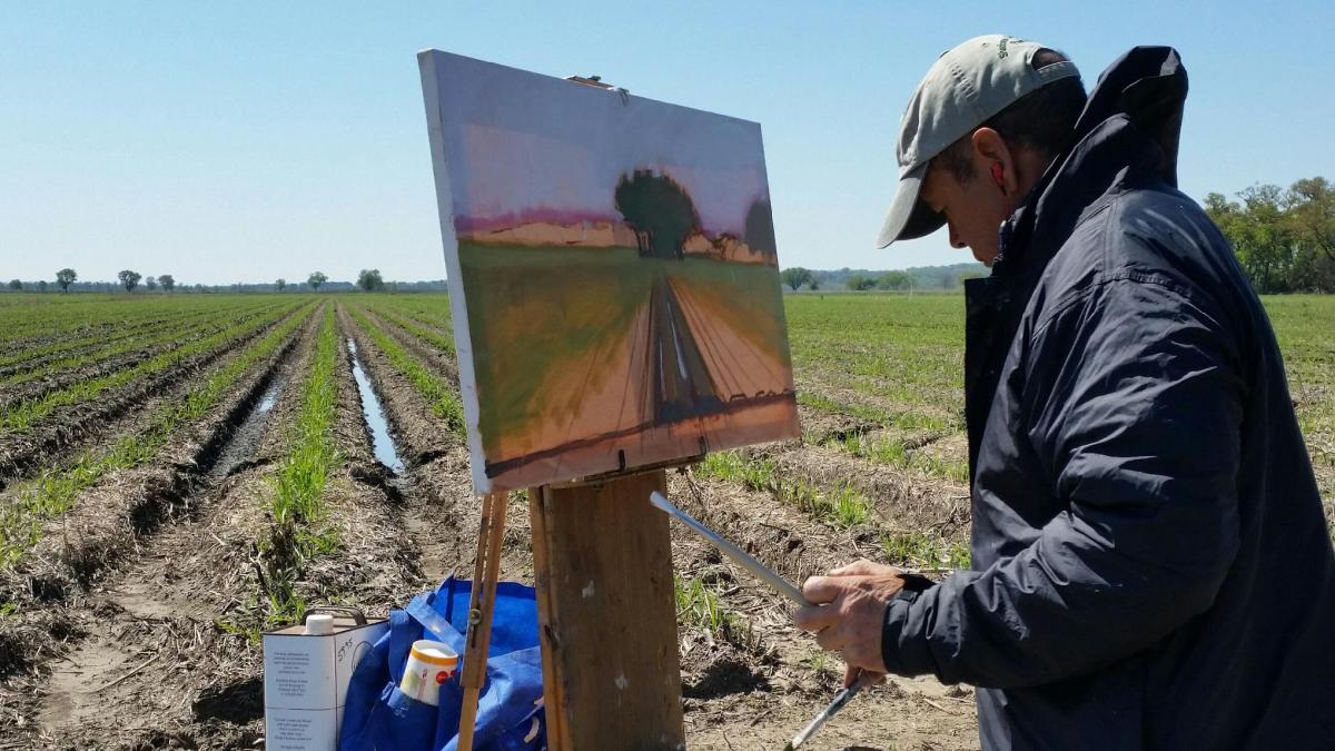Shadows on the Teche Plein Air competition artist painting in a field