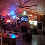 E&E Sports Bar interoir with tv table and chairs and bar decor