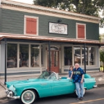 Sweet Caroline store exterior with man leaning against blue classic convertible car